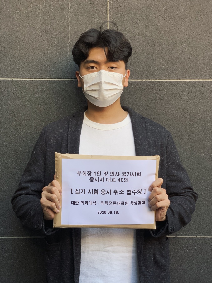 의대협 조승현 회장이 국시 취소 접수장 모음본을 들고 있다.