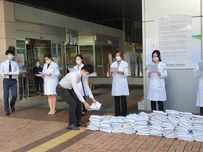 서울성모병원 전공의들이 23일 성명서를 낭독하고 자신들의 상징인 가운을 벗으며 파업에 돌입했다.